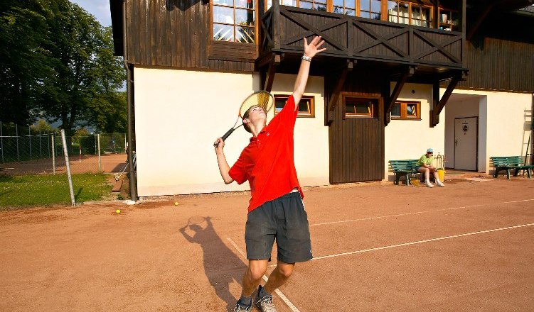 Tennisplatz in Payerbach, © Franz Zwickl Person beim Tennisspielen vor einem Gebäude.
