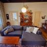 Orlet an der Rax, © Sofia Orlet Gemütliches Wohnzimmer mit grauem Sofa, Holzmöbeln und antiker Dekoration.