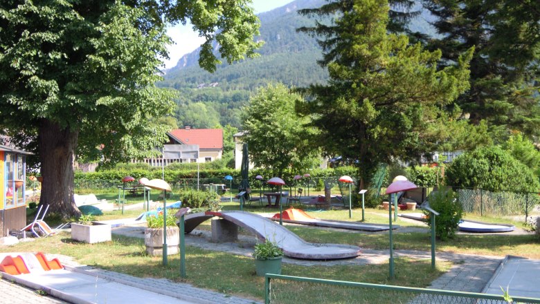 Minigolf Payerbach, © Marktgemeinde Payerbach Minigolfplatz in Payerbach mit Bäumen und Bergen im Hintergrund.