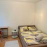 Schlafzimmer(c)wieneralpen, © Wiener Alpen Schlafzimmer mit Doppelbett, Schreibtisch und Stuhl.