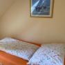 Einzelzimmer, © Wiener Alpen Ein Bett mit bunter Bettwäsche in einem Einzelzimmer, darüber ein gerahmtes Bild an der Wand.