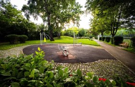 Generationenpark & Volleyball, © Gemeinde Wimpassing Ein Park mit Fitnessgeräten und Bäumen im Hintergrund.