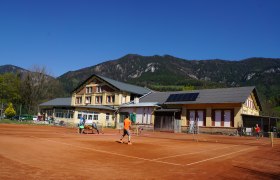 Sport- und Freizeitpark Eldorado, © Peter Grössl Tennisplatz vor einem Gebäude mit Bergen im Hintergrund.