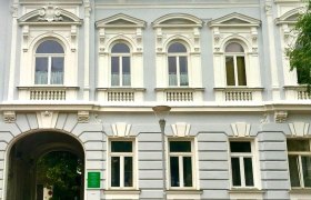Loft am Hauptplatz, © Stadt Gloggnitz Historisches Gebäude mit verzierten Fenstern und einem Torbogen.