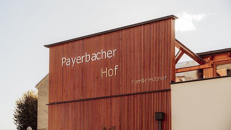 Payerbacherhof, © Payerbacherhof - Christopher Tarkus Holzfassade des Payerbacherhofs mit Schriftzug.