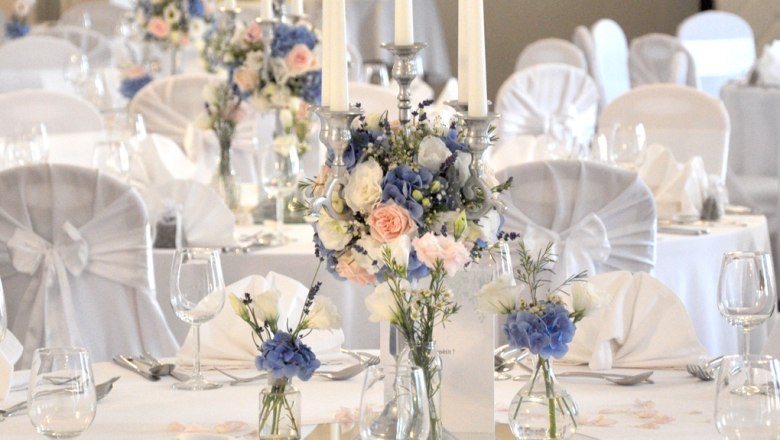 Feiern im Schloss Gloggnitz, © Günter Brentrup Elegante Tischdekoration mit Blumen und Kerzen in einem Festsaal.