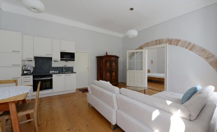 Apartment G2 im Gerhardthof Reichenau, © Gerhardthof Reichenau Helles Wohnzimmer mit Küche, Sofa und Esstisch.