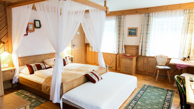 Doppelzimmer Kat. B, © Scharfegger´s Raxalpen Resort Gemütliches Hotelzimmer mit Himmelbett, Holzmöbeln und Teppichen.