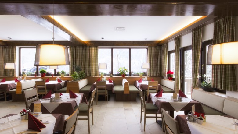 Restaurant, © Hotel Belvedere Innenansicht eines gemütlichen Restaurants mit Holzmöbeln, gedeckten Tischen und großen Fenstern.