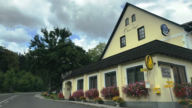 Gasthof Oberer Eggl, © Oberer Eggl Gasthof Oberer Eggl mit Blumen und Bushaltestelle.