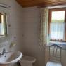 Badezimmer, © Wiener Alpen Ein Badezimmer mit Waschbecken, Bidet, Spiegel und Fenster mit Vorhängen.