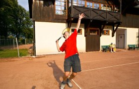 Tennisplatz in Payerbach, © Franz Zwickl Person beim Tennisspielen vor einem Gebäude.