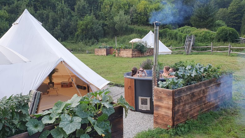 Glamping Wildnis Zentrum Nasswald, © Jonathan Clark Glamping-Zelte und Hot Tub in grüner Umgebung.