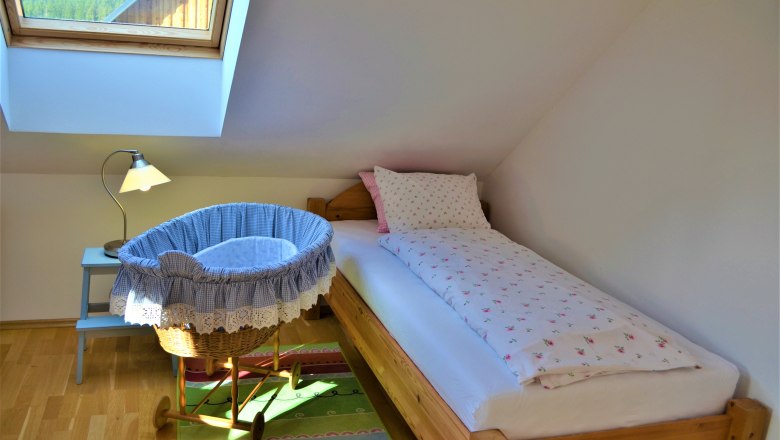 Schlafzimmer, © Gluschitz-Goebel Ein gemütliches Schlafzimmer mit Einzelbett, Babywiege und Dachfenster.