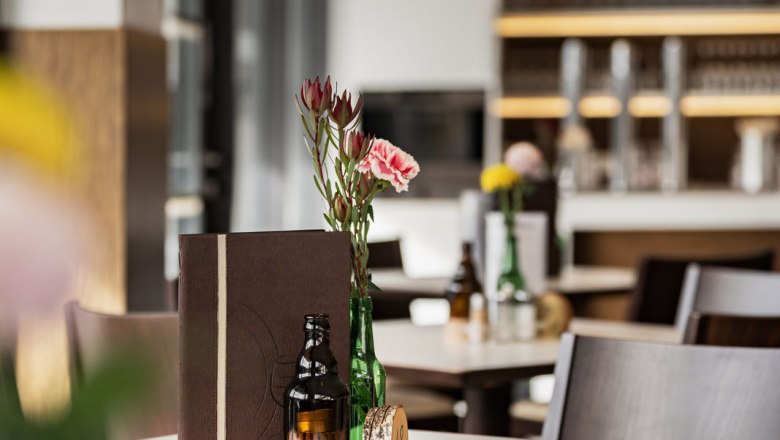 Bistro, © Kristina Polleres Innenansicht eines modernen Bistros mit dekorierten Tischen und einer Bar im Hintergrund.