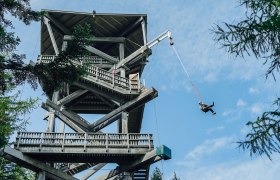 Millennium Jump am Hirschenkogel, © Semmering Hirschenkogel Bergbahnen GmbH Person springt mit einem Seil von einer Aussichtswarte.