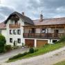 Ferienwohnungen Riedl, © Fam. Riedl Ein zweistöckiges Haus mit Balkon und Garage, umgeben von grüner Landschaft.