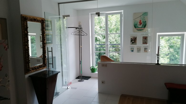 Eingangsbereich zur Ferienwohnung, © Wiener Alpen Eingangsbereich einer Ferienwohnung mit Spiegel, Kleiderständer und Bildern an der Wand.