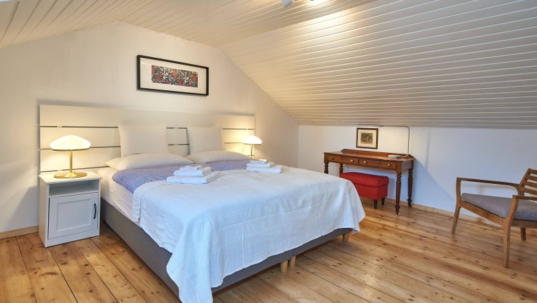 Top 4 - Schlafzimmer, © VP FeWo OG Gemütliches Schlafzimmer mit Doppelbett, Holzboden und Dachschräge.