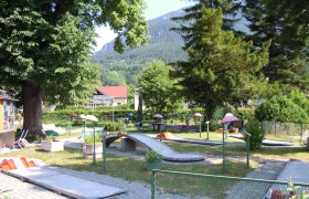 Minigolf Payerbach, © Marktgemeinde Payerbach Minigolfplatz in Payerbach mit Bäumen und Bergen im Hintergrund.