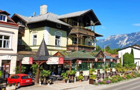 Café Reichenau, © Raxalpen Touristik Ein Café mit Terrasse und Bergblick in einer malerischen Umgebung.