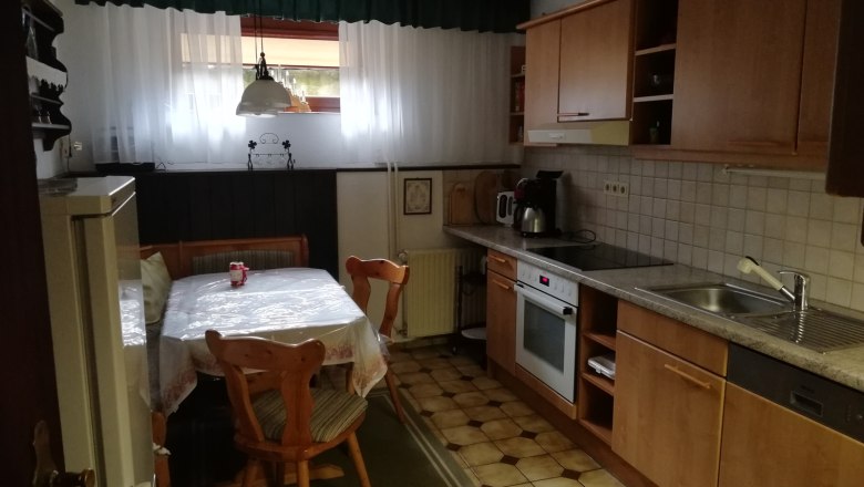 Küche, © Kesper Gemütliche Küche mit Holzmöbeln, Esstisch, Stühlen und Küchengeräten.