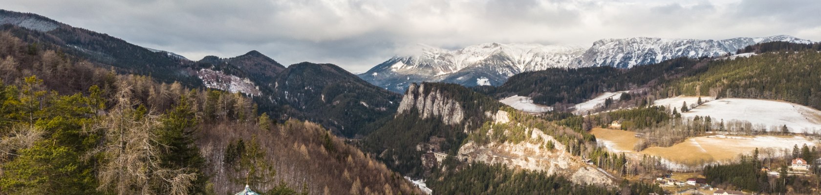 Winterwandern Doppelreiter Aussichtswarte Semmering, © Wiener Alpen - Martin Fülöp Panoramabild im Winter mit leichten Schnee und Ausblick auf umliegende Orte und Berglanschaften