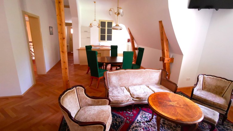 Wohnzimmer im Appartement Henriette, © Herrnhof Wohnzimmer mit antiken Möbeln und Holzbalken.