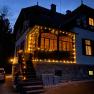 Orlet an der Rax, © Sofia Orlet Ein beleuchtetes Haus in der Dämmerung mit Lichterketten geschmückt.