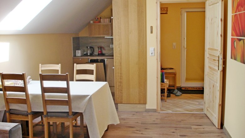 Ferienwohnung Essbereich, © Vadim Drozdov Essbereich einer Ferienwohnung mit Tisch, Stühlen und Küchenzeile.