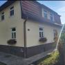 Leo-Hof Ferienwohnung Eva, © Leo-Hof/Sandra Reinisch Zweistöckiges gelbes Haus mit roten Dachziegeln und Blumenkästen an den Fenstern.