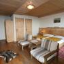 Komfort Doppelzimmer, © Scharfgger´s Raxalpen Resort Gemütliches Doppelzimmer mit Holzmöbeln, Doppelbett, Sesseln und Teppich.