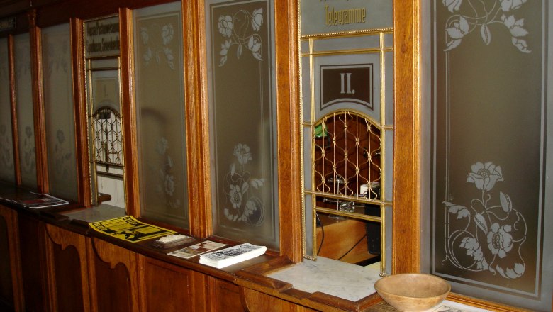 Schalter Postamt Küb, © Marktgemeinde Payerbach Historischer Postschalter mit Holzverkleidung und Glasfenstern.