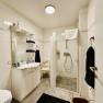Joes Coxy Apartment, © Brunner Modernes Badezimmer mit Dusche, Waschbecken und WC.