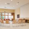 Seminarraum, © Traumbild - Gerhard Wolkersdorfer Ein leerer Seminarraum mit Stuhlkreis, Beamer, Leinwand und Flipchart.