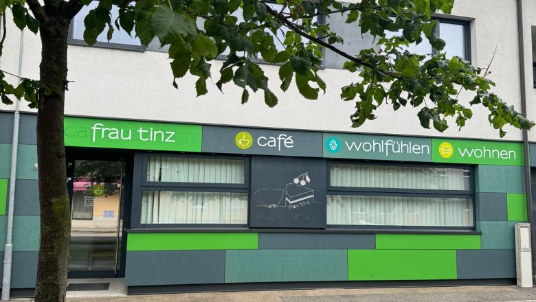 Hausansicht Cafe Frau Tinz, © Martina Lechner Außenansicht eines Cafés mit grüner Fassade und Baum im Vordergrund.