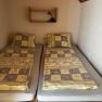 Ferienwohnungen Riedl, © Familie Riedl Zwei Einzelbetten mit gemusterten Bettdecken in einem kleinen Zimmer.