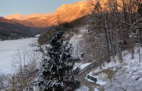 6d767414-dd04-425f-8cf1-08e1ec4fe488, © Martin Sturm Verschneite Landschaft mit Bergen im Hintergrund, die von der Abendsonne beleuchtet werden.