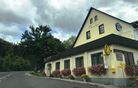 Gasthof Oberer Eggl, © Oberer Eggl Gasthof Oberer Eggl mit Blumen und Bushaltestelle.