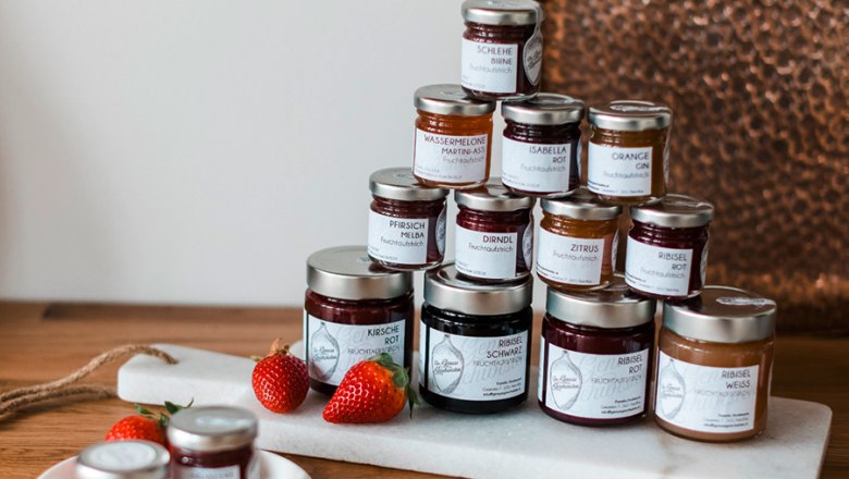 Genussgeschwister, © Seelensachen Fotografie | Genuss Geschwister Verschiedene Marmeladengläser auf einem Tisch arrangiert.