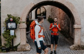 Semmering Bahnwanderweg, Bahnwandern, Wiener Alpen in Niederösterreich, © Wiener Alpen/nicoleseiser.at Zwei Wanderer stehen am Eingangstor zum Schloss Gloggnitz