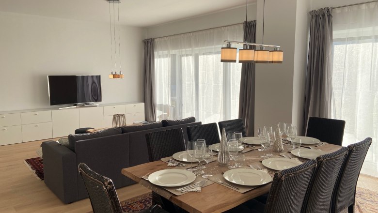 Wohn-Essbereich, © Wiener Alpen Moderner Wohn-Essbereich mit Esstisch, Stühlen, Sofa und Fernseher.