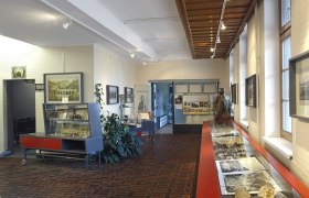 Weltkulturerbe Infozentrum am Bahnhof Semmering, © Wiener Alpen, Foto: Bene Croy Innenansicht des Weltkulturerbe Infozentrums am Bahnhof Semmering mit Ausstellungsstücken und Informationstafeln.