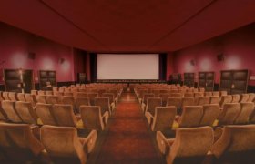 "Retro meets Modern", © Kino Wimpassing Leerer Kinosaal mit roten Wänden und beigen Sitzen und Leinwand