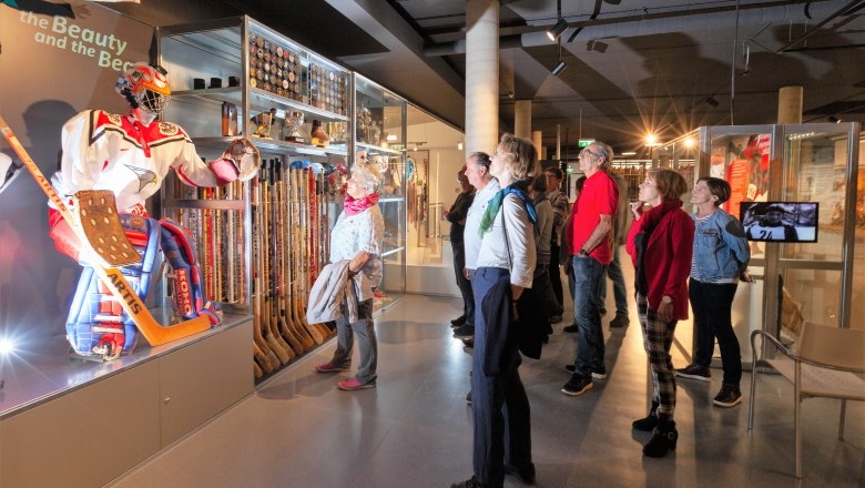 Wintersport Museum, © Karoline Karner Besucher betrachten eine Eishockey-Ausstellung im Wintersport Museum.
