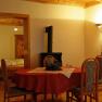 Die gemütlichen Wohnungen im Althammerhof, © Althammerhof, Julius Schneidhofer Gemütliches Wohnzimmer mit Esstisch, Holzofen und Sofa.