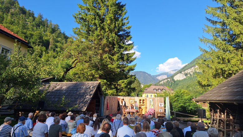 Freilufttheater in Nasswald mit Zuschauern und Bergkulisse.
