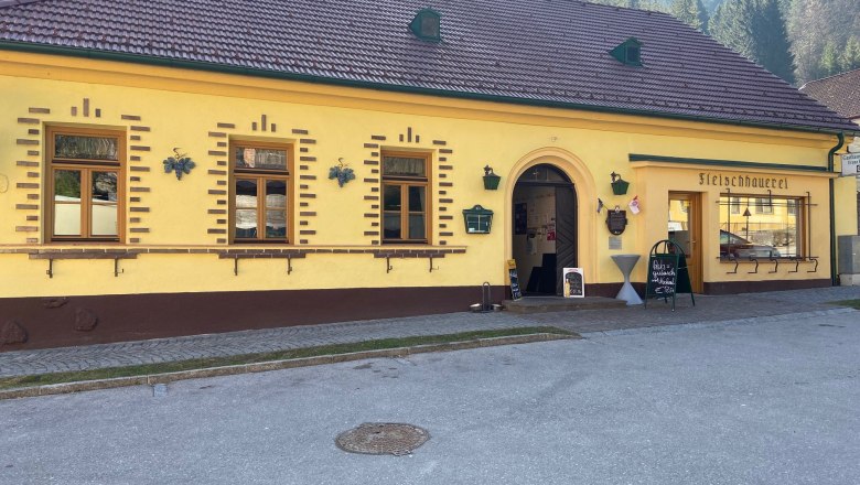 Gelbes Gebäude mit der Aufschrift 'Fleischhauerei' und einem Eingang.