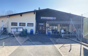 Au&szlig;enansicht eines Geb&auml;udes mit dem Schild 'Schmankerl-Eck'.