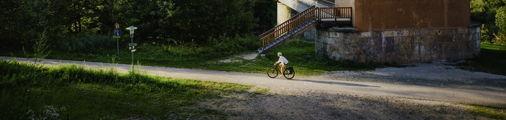 Eine Frau fährt auf dem Rad neben einem Viadukt